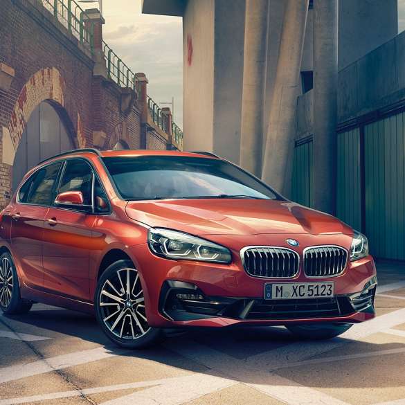Extérieur de la BMW Série 2 Active Tourer BMW Série 2 Active Tourer F45 restylage 2018 Sunset Orange metallic, vue de trois quart avant, en stationnement dans une ruelle