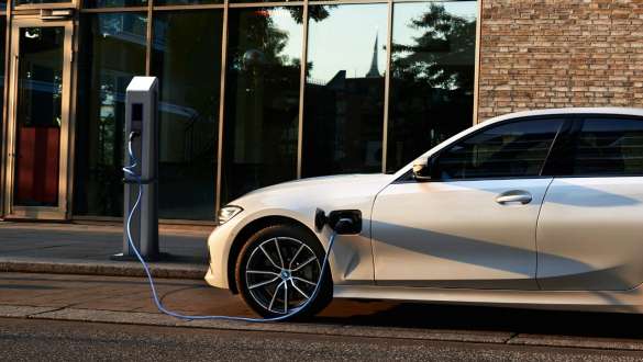 BMW Série 3 Berline hybride rechargeable 2021 G20, vue de profil BMW Série 3 Berline hybride rechargeable 2021 G20, vue de trois quarts de profil branchée à une borne de recharge