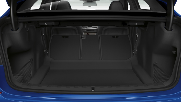 BMW Série 3 Berline, trappe de passage Gros plan du compartiment à bagages ouvert avec les sièges arrière repliés à demi.