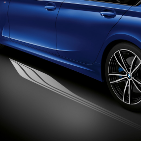 BMW Série 3 Berline, éclairage d’ambiance Vue de face du poste de conduite côté conducteur de la BMW Série 3 Berline avec espace aux pieds baigné de lumière bleue diffusée par l’éclairage d’ambiance