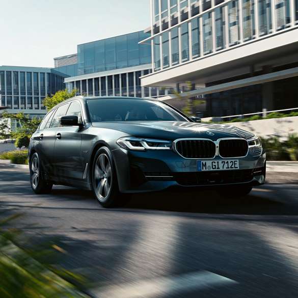 Extérieur de la BMW Série 5 Touring G31 BMW Série 5 Touring G31 restylage 2020 en Phytonicblau, vue de trois quarts avant, en mouvement dans un paysage urbain