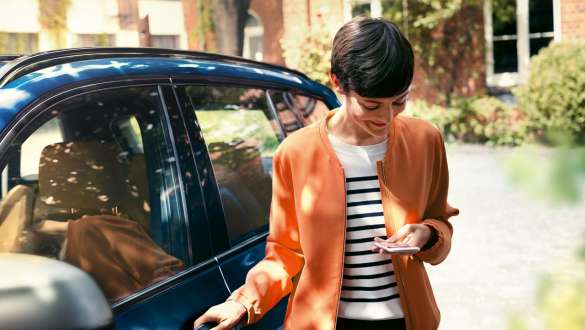 Femme avec vue sur son smartphone, BMW Série 5 Touring G31 Femme descend de la BMW avec vue sur son smartphone, BMW Série 5 Touring G31 restylage 2020