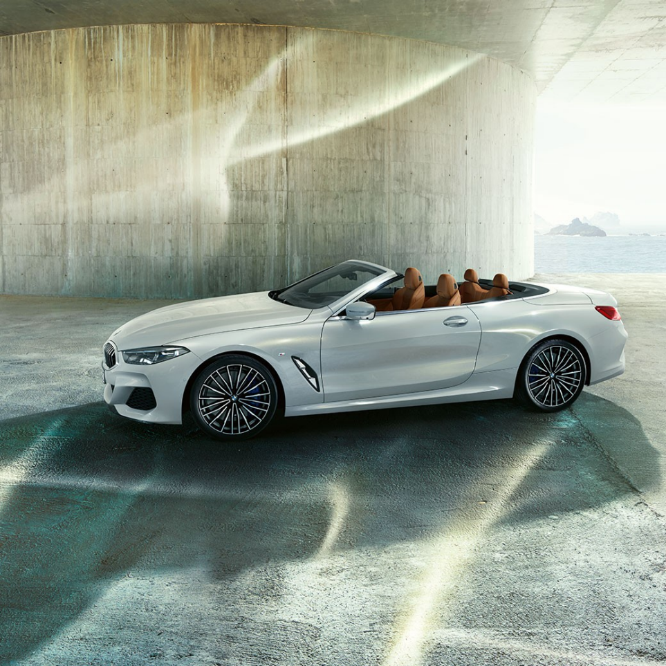 BMW M850i xDrive en Mineralweiß metallic, vue de profil avec capote souple ouverte. BMW M850i xDrive en Mineralweiß metallic, vue de profil avec capote souple ouverte.