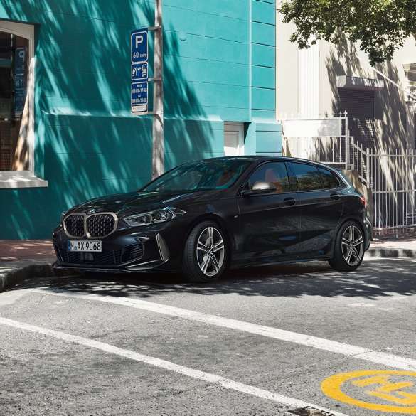 BMW M135i xDrive, vue de trois quarts de profil F40. BMW M135i xDrive en Saphirschwarz metallic, vue de trois quarts de profil, en stationnement F40.