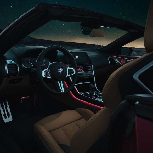 BMW M8 Competition Cabrio, poste de conduite F91. BMW M8 Competition Cabrio, poste de conduite de nuit avec volant M en cuir et éclairage d’ambiance rouge F91.