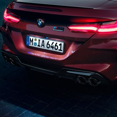 BMW M8 Competition Cabrio, vue en gros plan de l’arrière F91. BMW M8 Competition Cabrio en Motegi Rot metallic, vue en gros plan de l’arrière avec feux arrière à LED et badge M8 Competition F91.