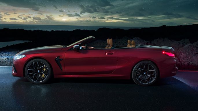 BMW M8 Competition Cabrio, vue de profil F91. BMW M8 Competition Cabrio en Motegi Rot metallic avec capote ouverte, vue de profil nocturne sous un ciel étoilé F91.