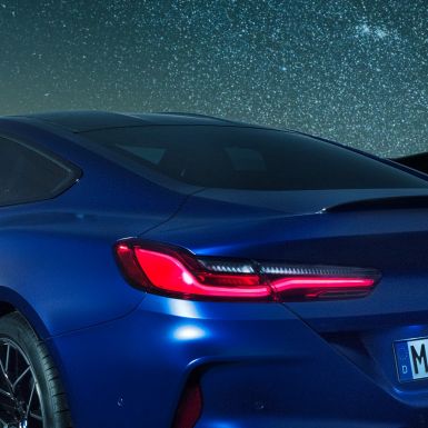 Becquet M arrière F92. BMW M8 Competition Coupé en Marina Bay Blau metallic, vue en gros plan de la carrure de nuit, avec diffuseur M en Carbon Schwarz F92.