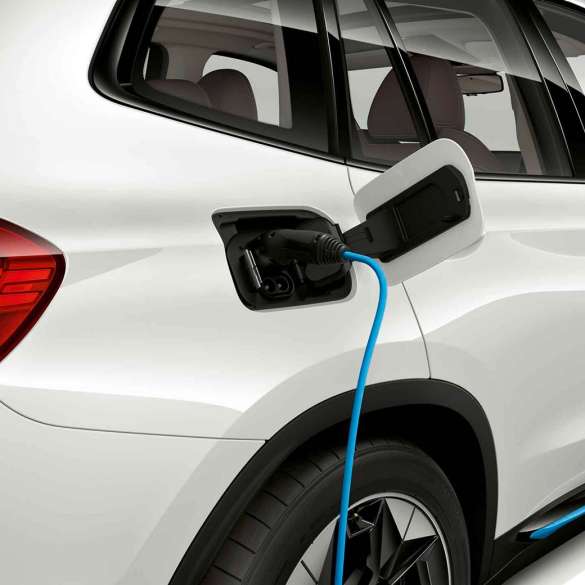 High Power Charging BMW iX3 G08 sur une borne de recharge publique, vue de profil High-Power Charging BMW iX3 G08 2020 Mineralweiß metallic sur une borne de recharge publique, vue de profil