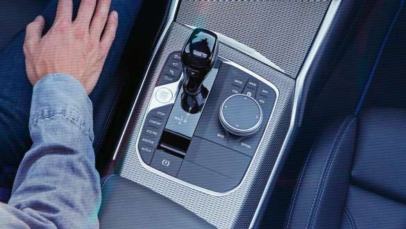 BMW 3 Reeks Berline, sportversnellingsbak Steptronic G20. Detailaanzicht vanuit vogelperspectief van de middenconsole van de BMW 3 Reeks Berline met versnellingspook en sportversnellingsbak Steptronic G20.