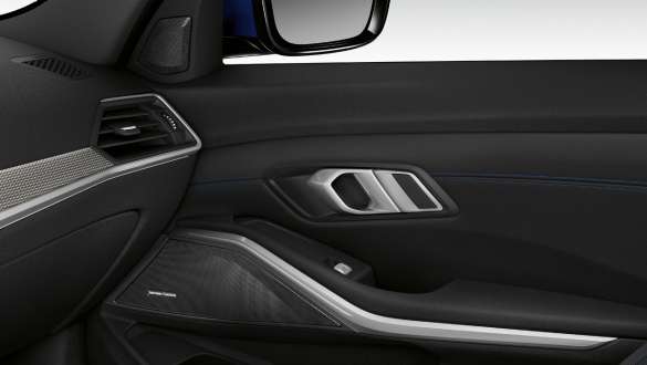 BMW 3 Reeks Berline, Harman Kardon surround sound system G20. Close-up van de binnenkant van de verlichte passagiersdeur met ingebouwde luidspreker van het Harman Kardon surround sound system G20.