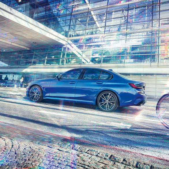 BMW 3 Reeks Berline, zijaanzicht G20. Zijaanzicht in stilstand van de BMW 3 Reeks Berline overdag voor glazen gebouw G20.