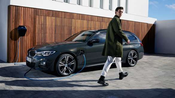 Plug-in-hybride BMW 3 Reeks Touring 2021 G21 driekwart zijaanzicht aan BMW Wallbox Plug-in-hybride BMW 3 Reeks Touring 2021 G21 driekwart zijaanzicht aan BMW Wallbox met model