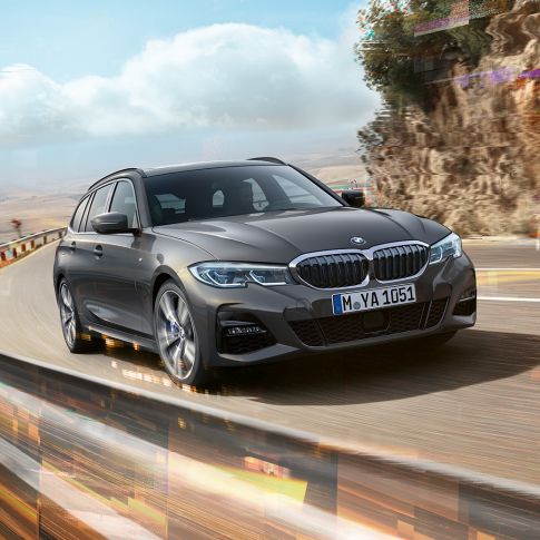BMW 3 Reeks Touring, driekwart vooraanzicht design G21 BMW 3 Reeks Touring, driekwart vooraanzicht tijdens het rijden op een brug in een landelijke omgeving G21
