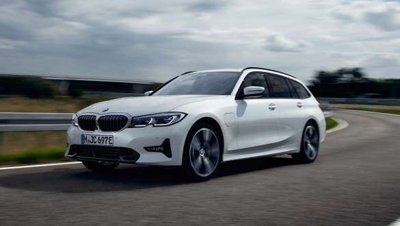 Plug-in-hybride BMW 3 Reeks Touring 2021 G21 driekwart vooraanzicht rijdend Plug-in-hybride BMW 3 Reeks Touring 2021 G21 driekwart vooraanzicht rijdend op de weg