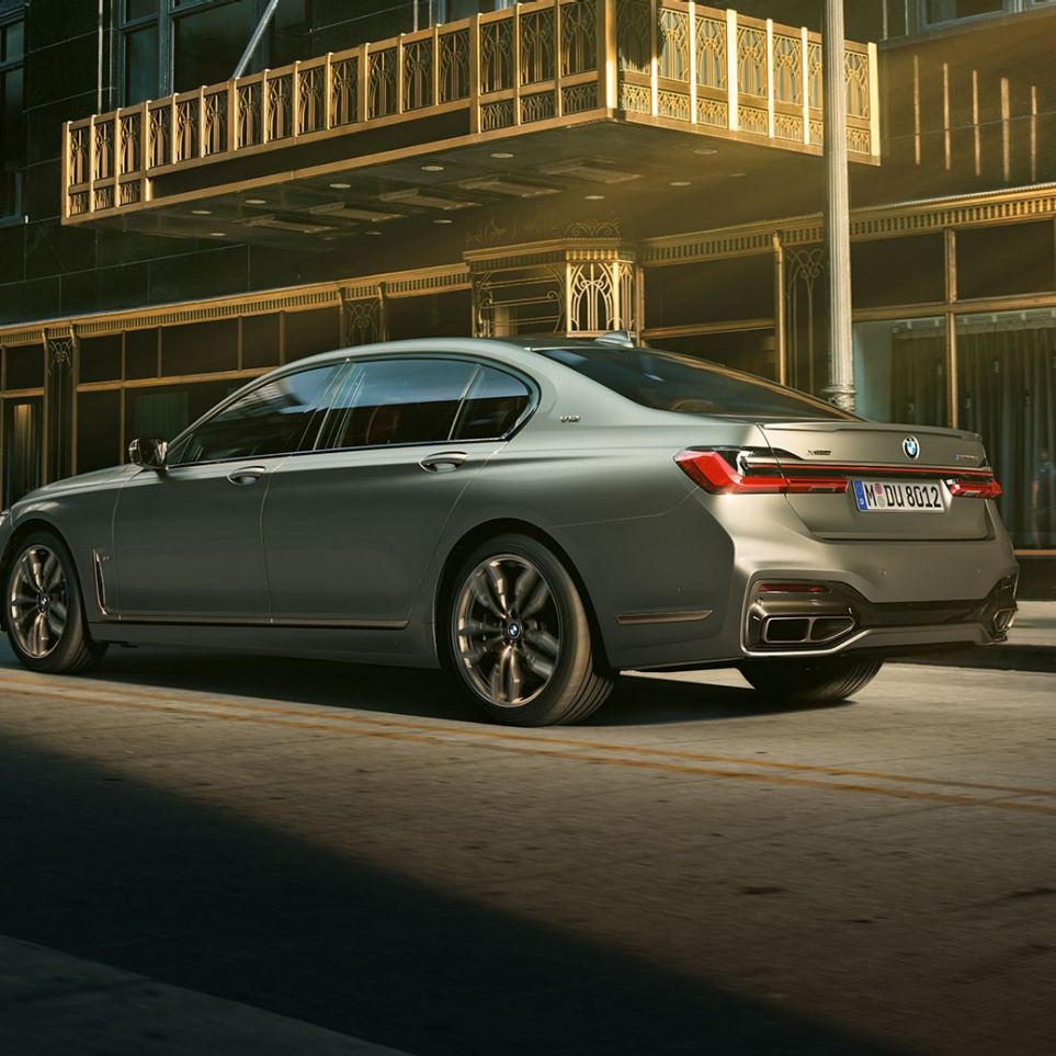 BMW M760Li xDrive met V12-motor G11 BMW M760Li xDrive, schuin achteraanzicht voor wolkenkrabbers in stedelijke omgeving G11