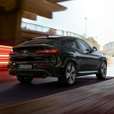 BMW X4 M40i, driekwart achteraanzicht G02. BMW X4 M40i in Saphirschwarz metallic, exterieur, driekwart achteraanzicht rechts met lichtstrepen G02.