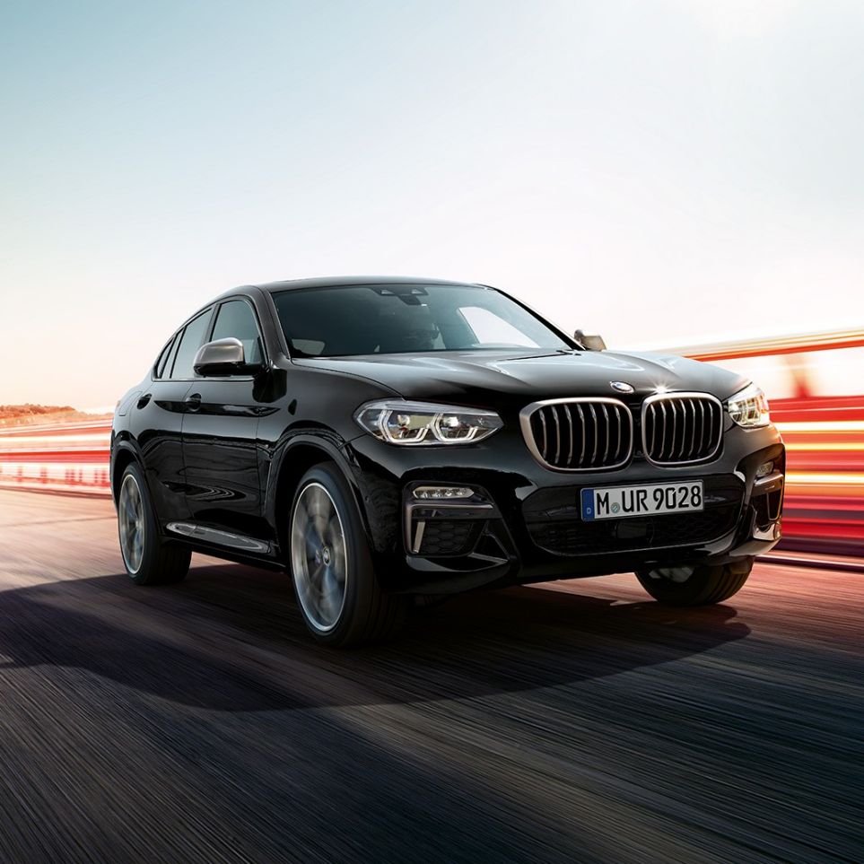 BMW X4 M40i en BMW X4 M40d, driekwart vooraanzicht G02. BMW X4 M40i en BMW X4 M40d in Saphirschwarz metallic, exterieur, driekwart vooraanzicht links met lichtstrepen G02.