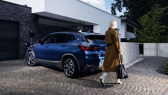 Plug-in-hybride BMW X2 xDrive25e F39 driekwart achteraanzicht ladend Plug-in-hybride BMW X2 xDrive25e F39 driekwart achteraanzicht ladend met model