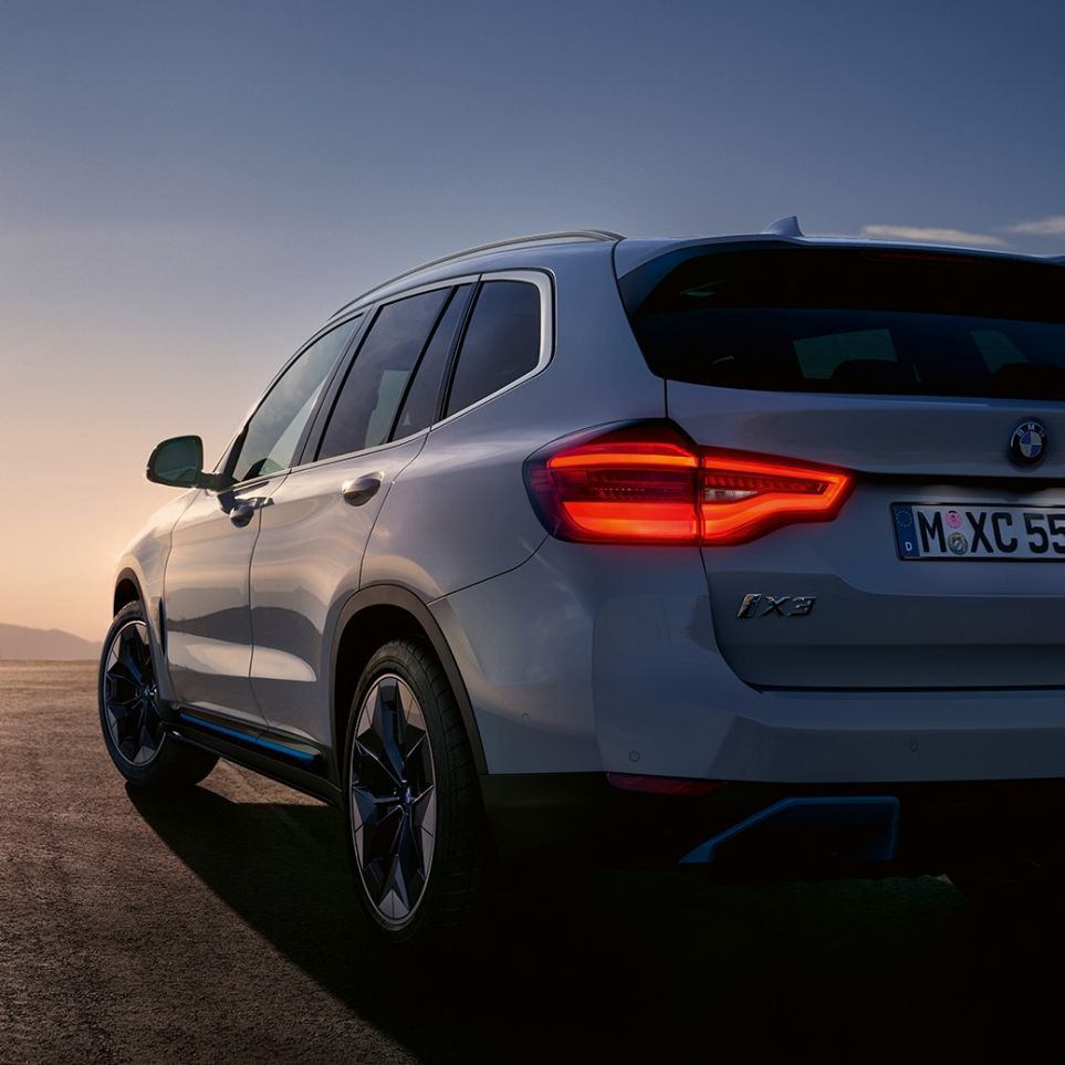 BMW iX3 G08 driekwart achteraanzicht op de weg BMW iX3 G08 2020 Mineralweiß metallic driekwart achteraanzicht op de weg