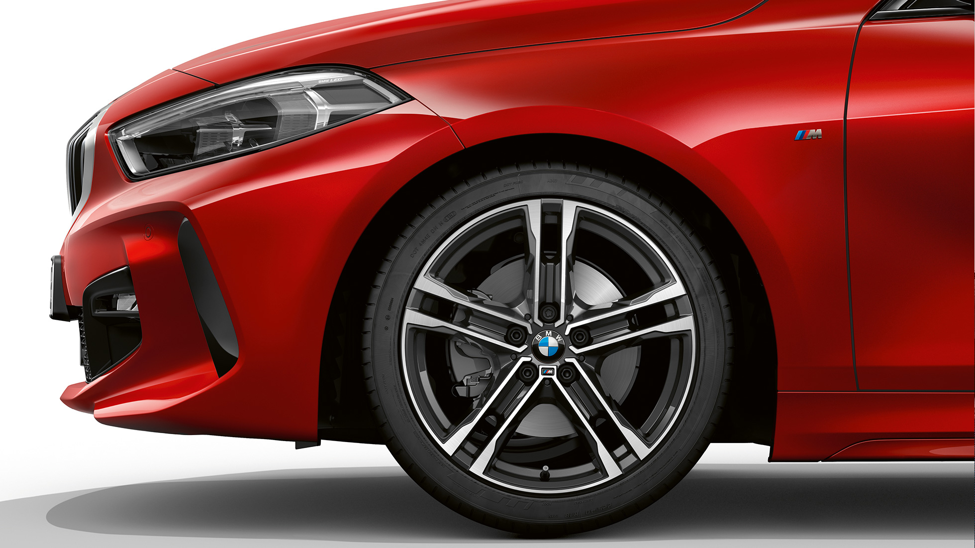 BMW Série 1, Modèle M Sport, vue de profil avant F40. BMW Série 1, Modèle M Sport en Melbourne Rot metallic, vue latérale avant, avec jantes BMW M 17" en alliage léger à doubles rayons 550 M, en exécution bicolore F40.
