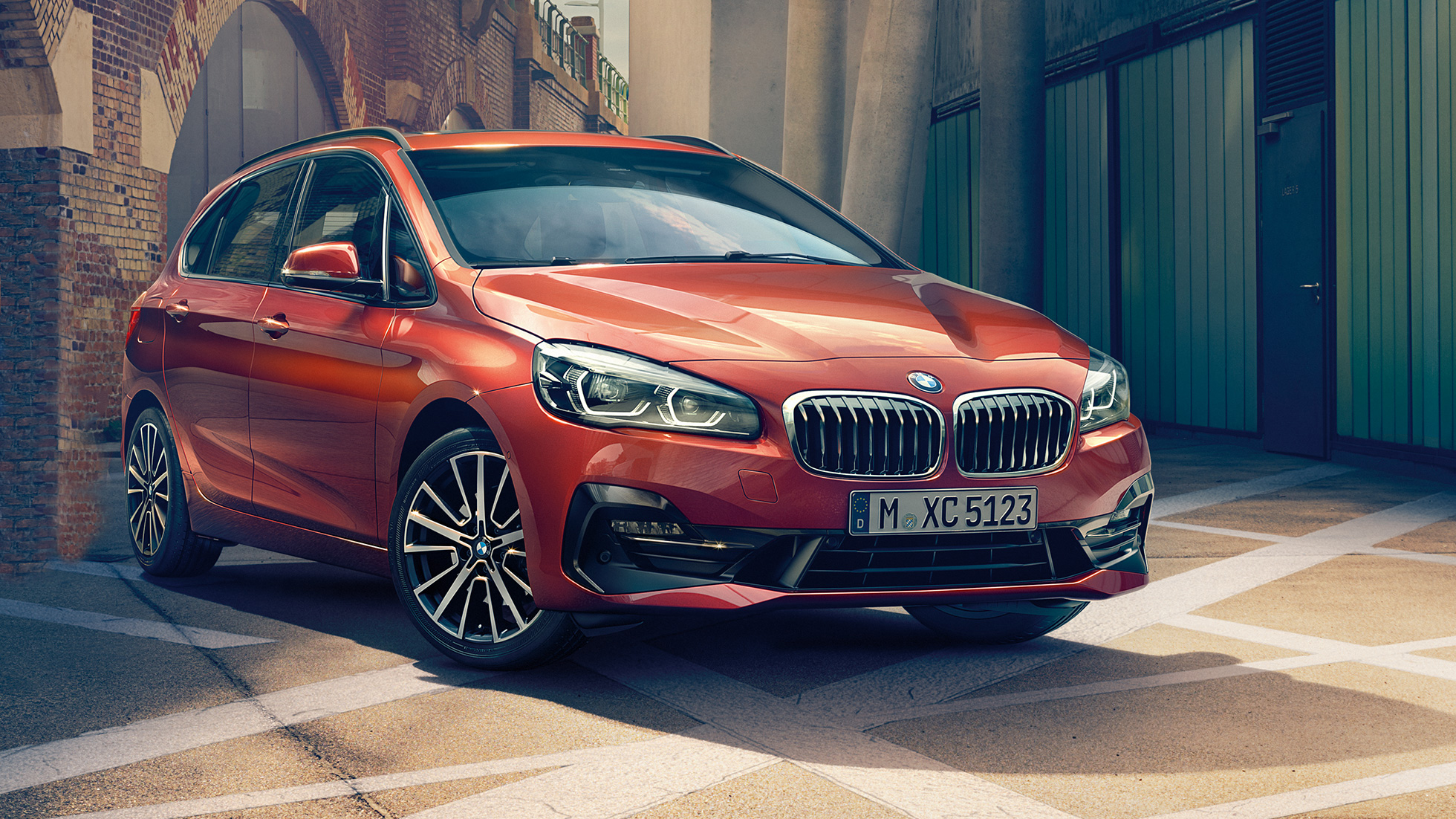 Extérieur de la BMW Série 2 Active Tourer BMW Série 2 Active Tourer F45 restylage 2018 Sunset Orange metallic, vue de trois quart avant, en stationnement dans une ruelle