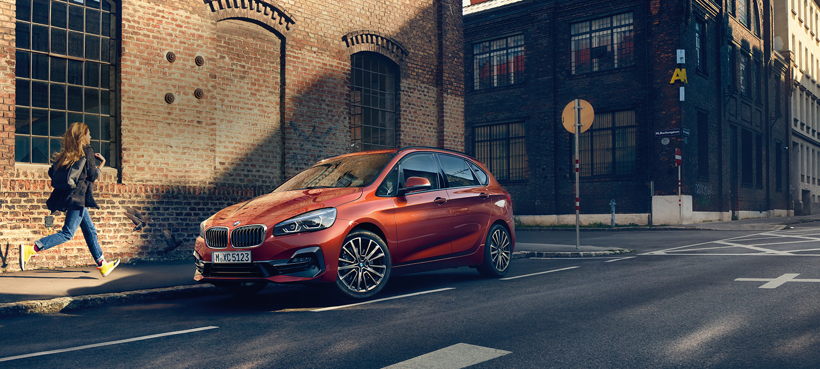 BMW Série 2 Active Tourer en stationnement BMW Série 2 Active Tourer F45 restylage 2018 Sunset Orange metallic, vue de trois quart avant, en stationnement sur la route