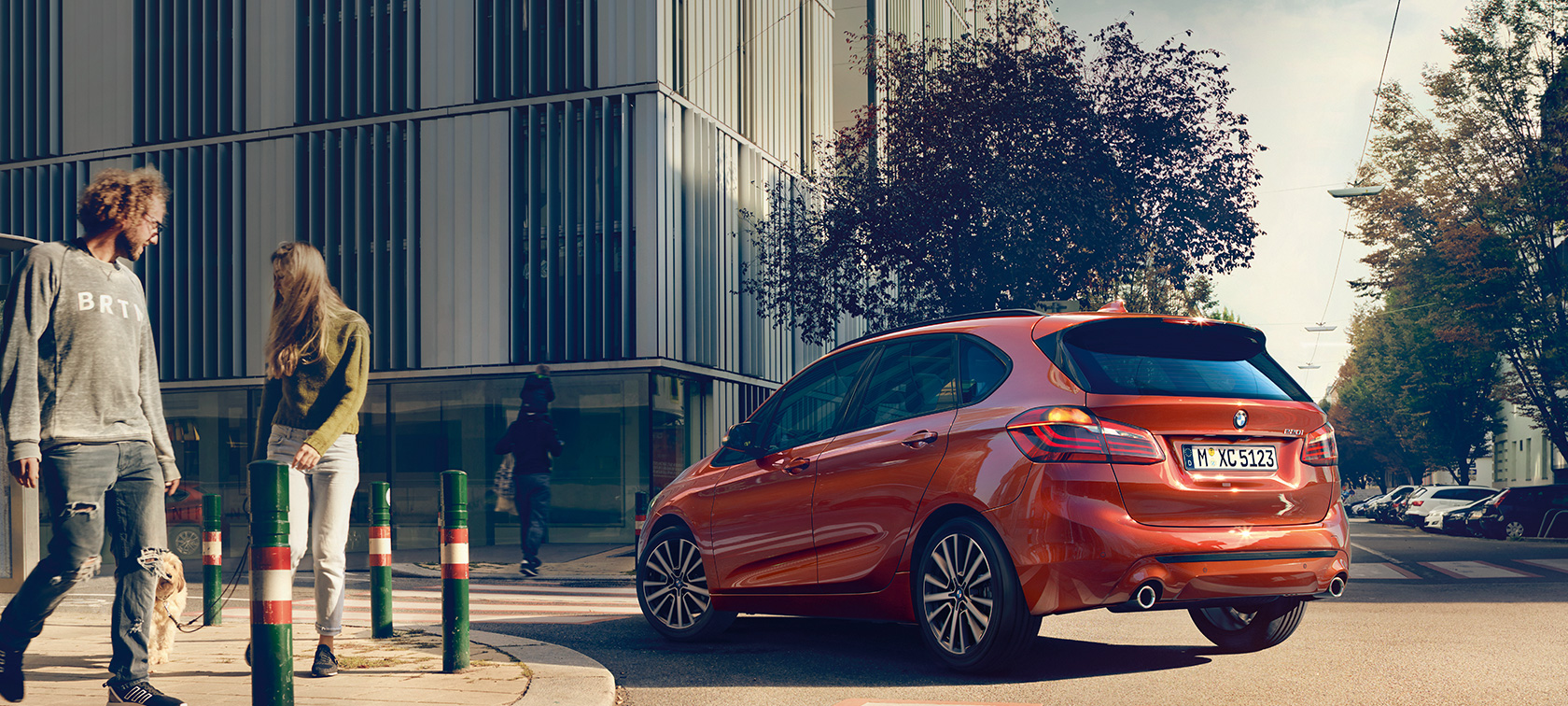 Vue de trois quarts arrière de la BMW Série 2 Active Tourer 220i BMW Série 2 Active Tourer 220i F45 restylage 2018 Sunset Orange metallic, vue de trois quart de profil, en mouvement sur la route