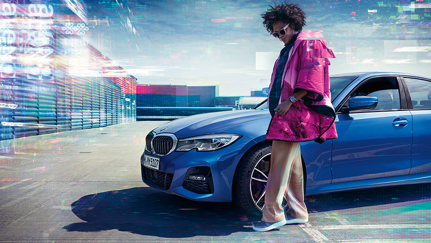 BMW 3 Reeks Berline (G20), Portimao Blau metallic, 7/8-voorkant BMW 3 Reeks Berline (G20), Portimao Blau metallic, 7/8-voorkant op parkeerdek met persoon op de voorgrond