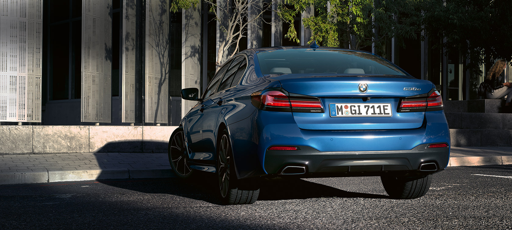 BMW 5 Reeks Berline eDrive (G30), Phytonicblau metallic BMW 5 Reeks Berline eDrive (G30), Phytonicblau metallic, achteraanzicht parkerend voor gebouw