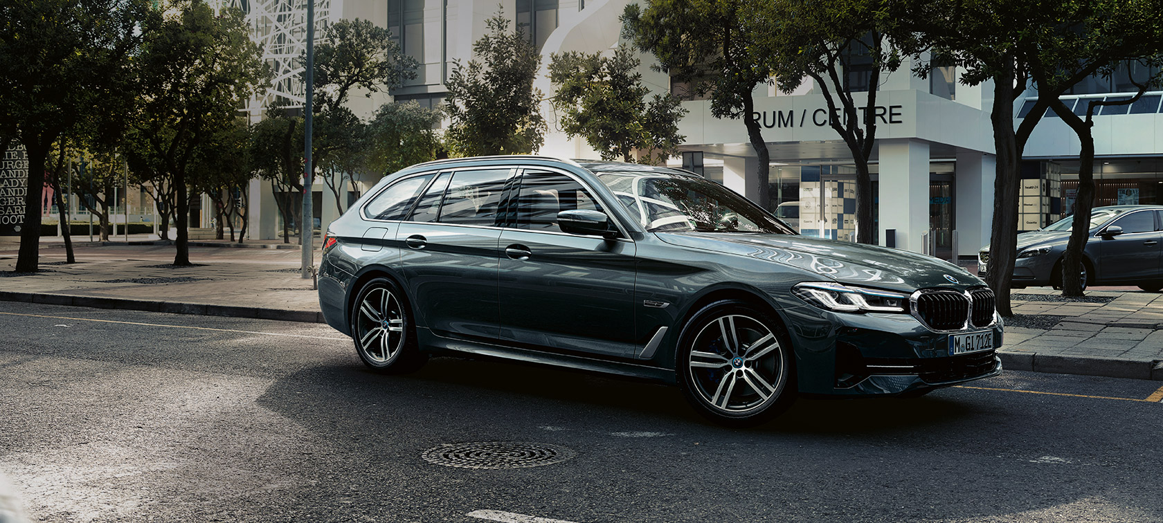 BMW Série 5 Touring G31 restylage 2020 en Sophistograu , vue avant, en mouvement dans un paysage urbain