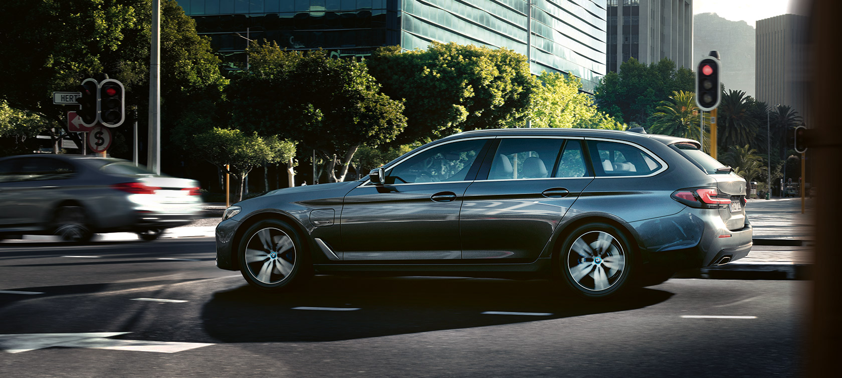 BMW 530e Touring G31 LCI en Sophistograu metallic, à l’arrêt devant des bâtiments BMW 530e Touring G31 LCI en Sophistograu metallic, à l’arrêt devant des bâtiments
