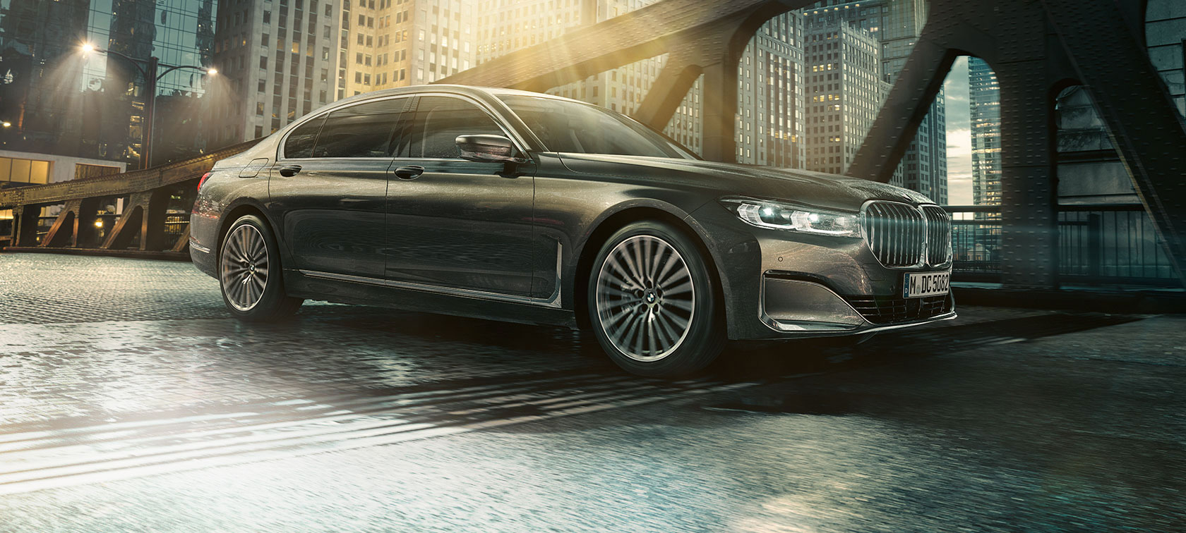 BMW 7 Reeks, zijaanzicht G11 BMW 7 Reeks staat in zijaanzicht met open deur voor verlicht hotel G11