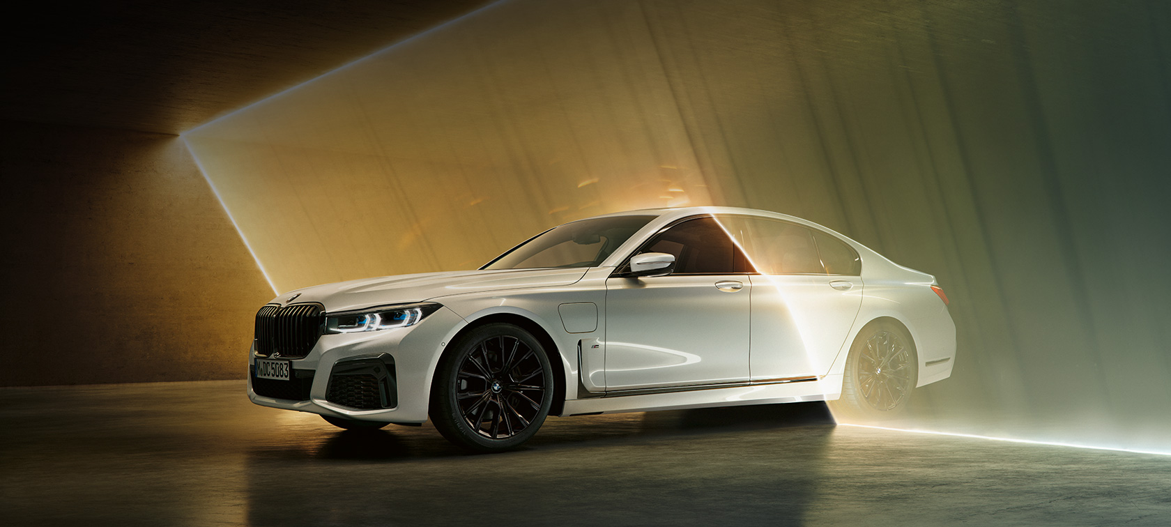 BMW 7 Reeks, wit, driekwart vooraanzicht G11 BMW 7 Reeks: witte BMW in driekwart vooraanzicht omgeven door lichtstraal G11