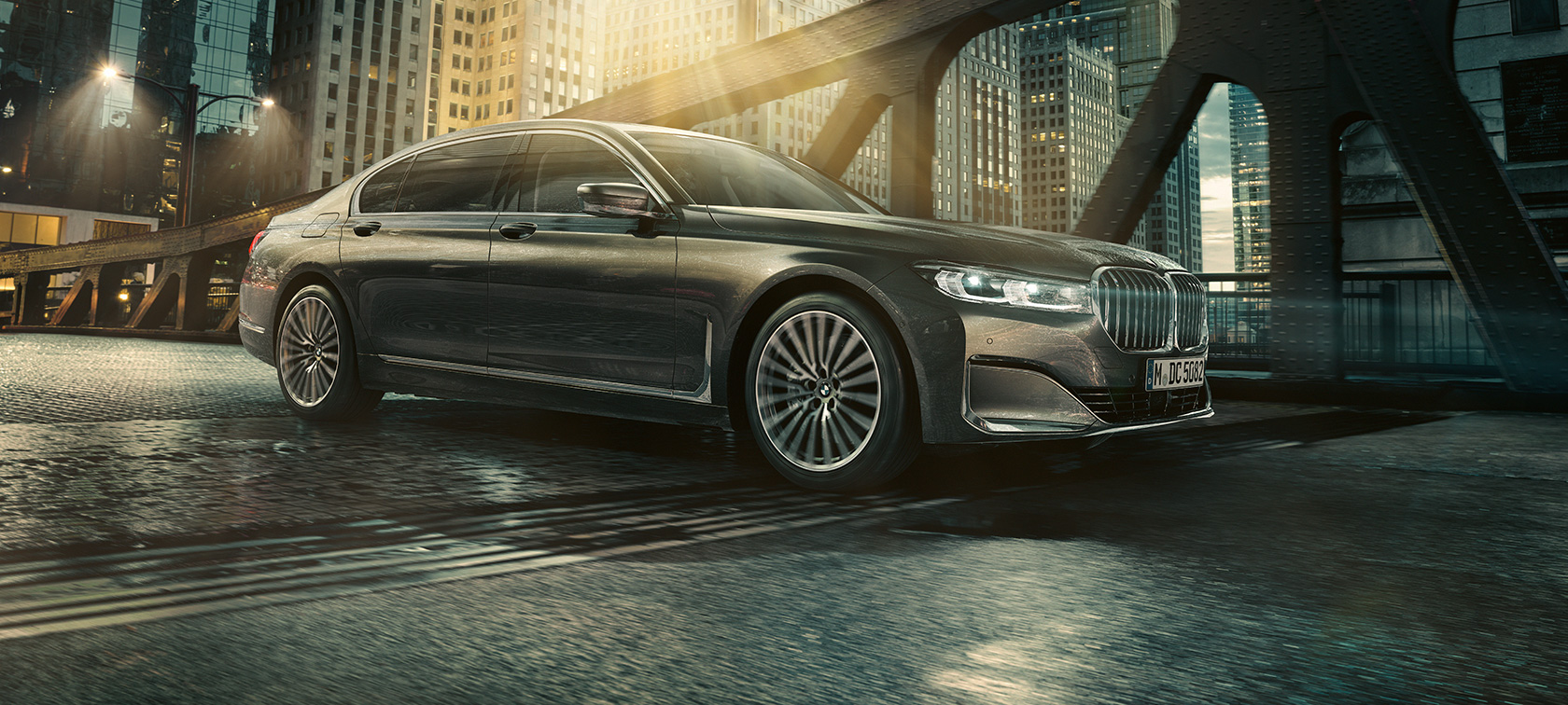 BMW 7 Reeks, zijaanzicht BMW 7 Reeks staat in zijaanzicht met open deur voor verlicht hotel