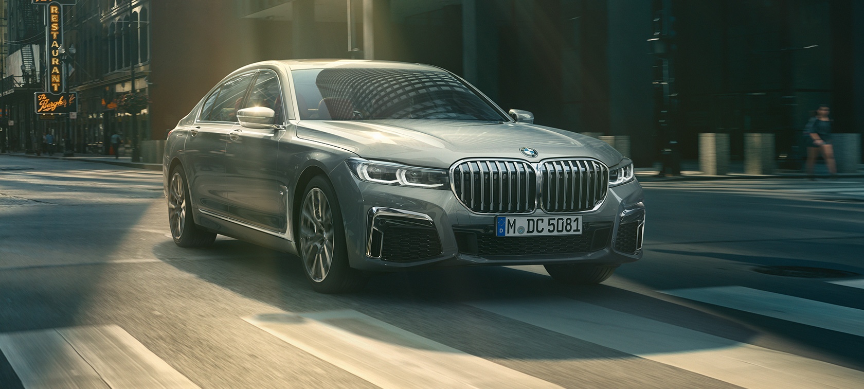 Grijze BMW 7 Reeks rijdend, driekwart vooraanzicht Grijze BMW 7 Reeks rijdt in driekwart vooraanzicht door stedelijke omgeving
