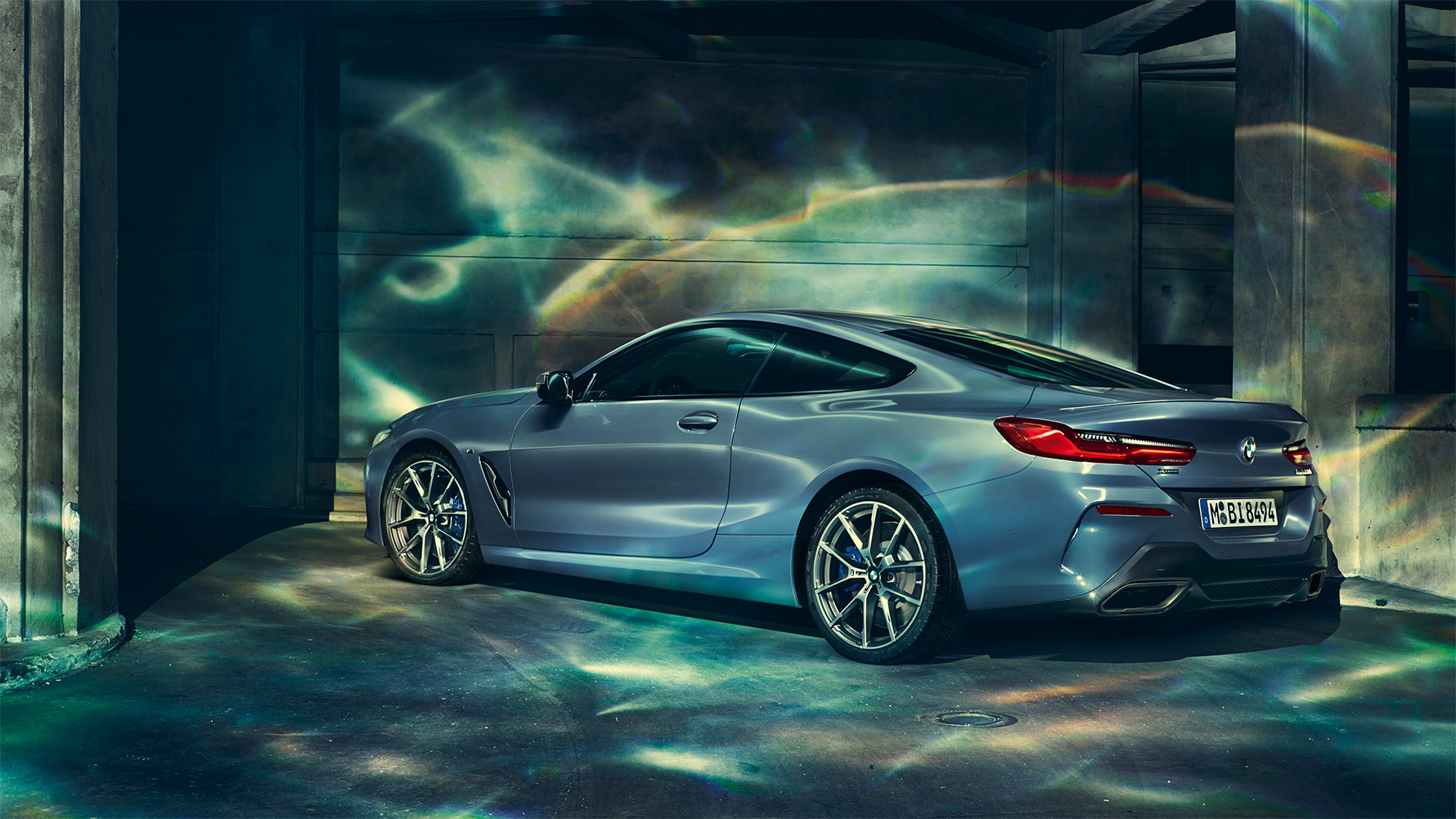 BMW 8 Serie, driekwart achteraanzicht Driekwart achteraanzicht van een BMW 8 Serie Coupé met op de achtergrond een nachtelijke skyline.