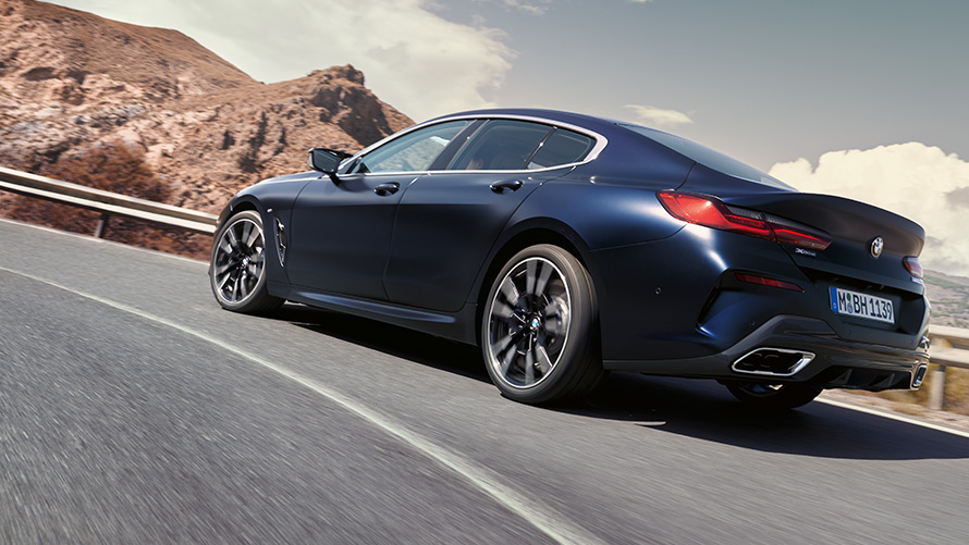 BMW 840i xDrive Gran Coupé Pack M Sport G16 LCI restylage 2022 en mouvement sur une route de montagne BMW 840i xDrive Gran Coupé Pack M Sport G16 LCI restylage 2022 BMW Individual Frozen Tansanitblau metallic vue de trois quarts arrière en mouvement sur une route de montagne