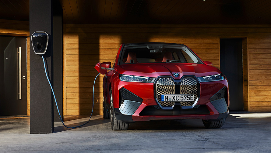 BMW iX i20 elektrische SUV BMW iX xDrive50 laden BMW iX i20 2021 elektrische SUV BMW iX xDrive50 Aventurinrot aan een BMW Wallbox opladen laden