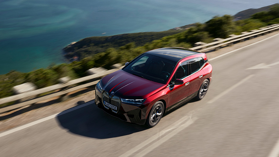 BMW iX i20 elektrische SUV BMW iX xDrive50 performance BMW iX i20 2021 elektrische SUV BMW iX xDrive50 Aventurinrot op de weg rijdend performance