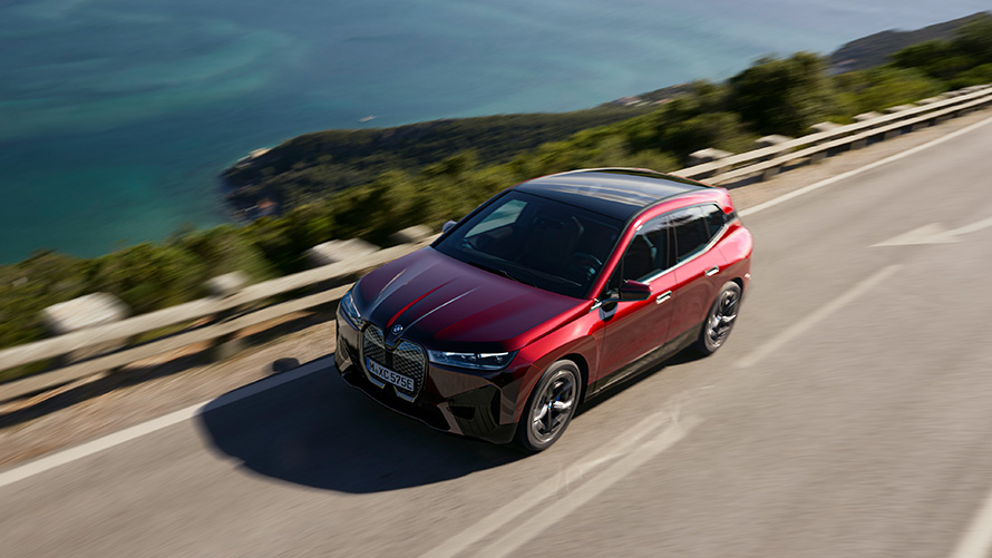 BMW iX i20 elektrische SUV BMW iX xDrive50 performance BMW iX i20 2021 elektrische SUV BMW iX xDrive50 Aventurinrot op de weg rijdend performance
