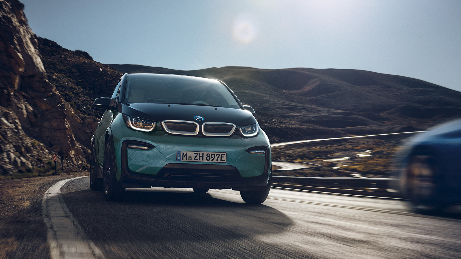BMW i3 2018 vue de profil en mouvement I01 BMW i3 I01 2018 Jucarobeige avec accent Frozen Grey metallic vue de profil roulant dans un décor urbain