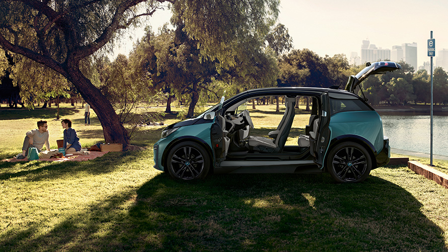 BMW i3 2018 dans le parc I01 BMW i3 I01 2018 Jucarobeige avec accent Frozen Grey metallic vue latérale avec portes ouvertes dans le parc I01