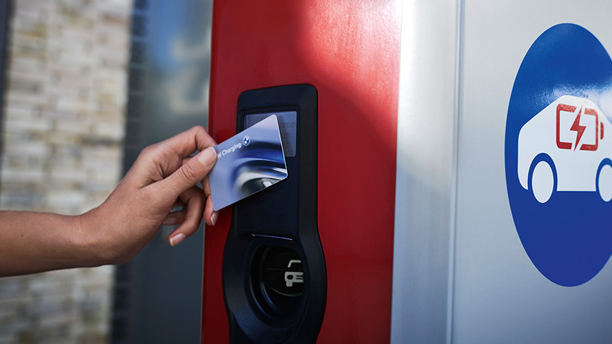 Persoon houdt BMW Charging Card aan openbare laadpaal Persoon houdt BMW Charging Card aan openbare laadpaal