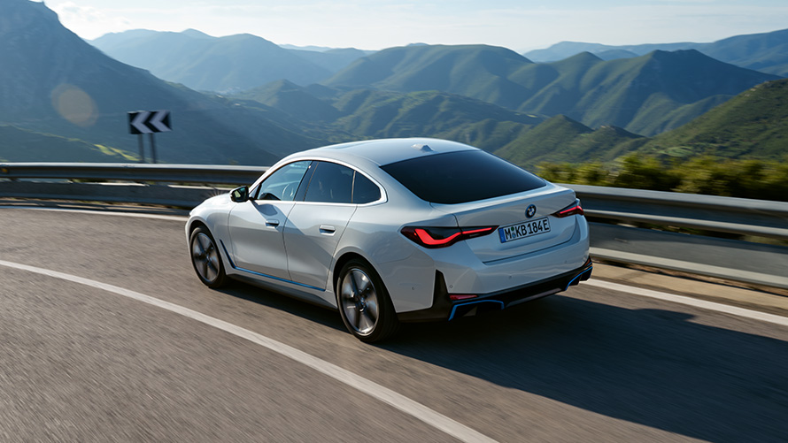 Driekwart achteraanzicht BMW i4 eDrive40 G26 2021 rijdend BMW i4 eDrive40 G26 2021 Mineralweiß driekwart achteraanzicht rijdend