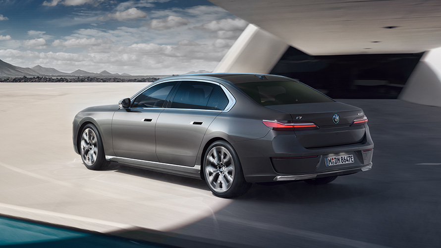 BMW i7 G70 BMW Individual Oxid grey metallic 3/4 achteraanzicht staand voor gebouw BMW i7 G70 3/4 achteraanzicht