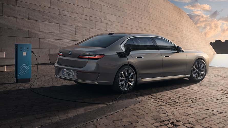 BMW i7 G70 3/4 achteraanzicht BMW i7 G70 BMW Individual Oxid grey metallic 3/4 achteraanzicht staand voor gebouw