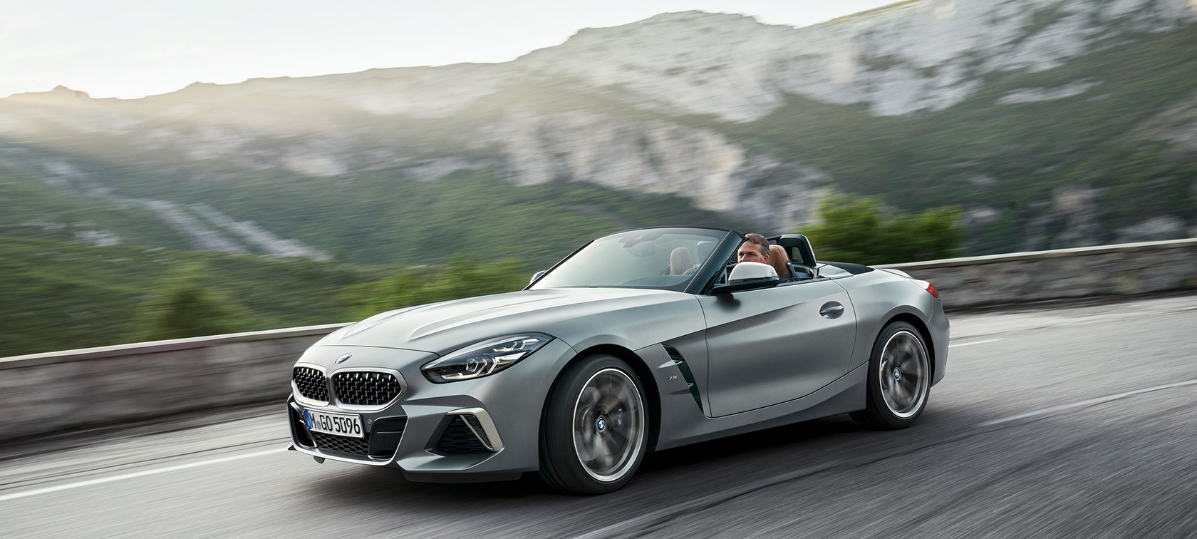 BMW Z4 M40i G29 en mouvement dans un paysage de montagnes BMW Z4 Roadster M40i G29 2019 Cabrio BMW Individual Frozen Grey metallic grau, vue de trois quarts avant roulant devant un paysage de montagnes