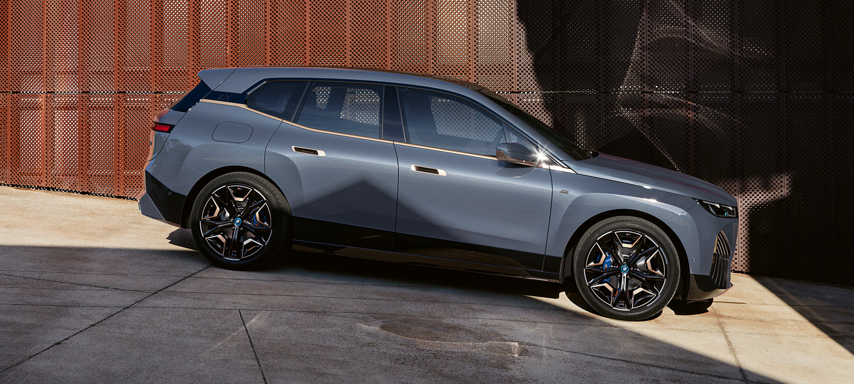 BMW iX M60 i20 2022 elektrische SUV BMW Individual Storm Bay metallic zijaanzicht parkerend