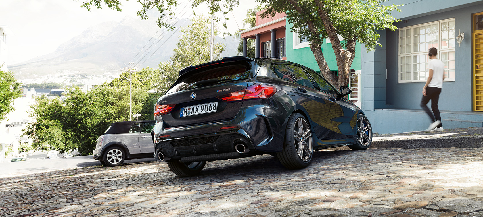 BMW M135i xDrive, driekwart achteraanzicht F40. BMW M135i xDrive in Saphirschwarz metallic driekwart achteraanzicht bij het parkeren voor een woonhuis F40.